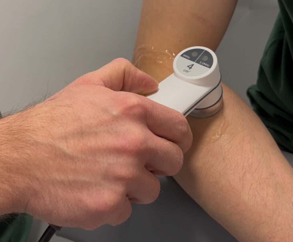 Fizjoterapeuta wykonujący zabieg z zakresu fizykoterapii.